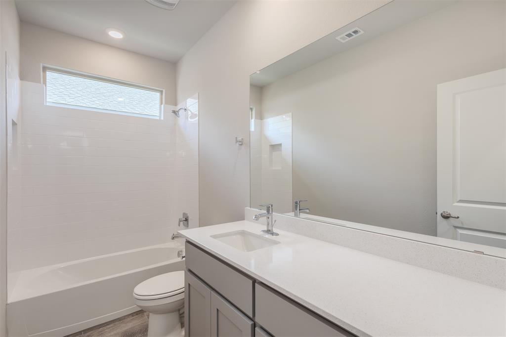 14621 Bootes Drive Haslet, TX 76052 - Photo 10 of 40 Bathroom with vanity, shower combination, and dark wood finished floors