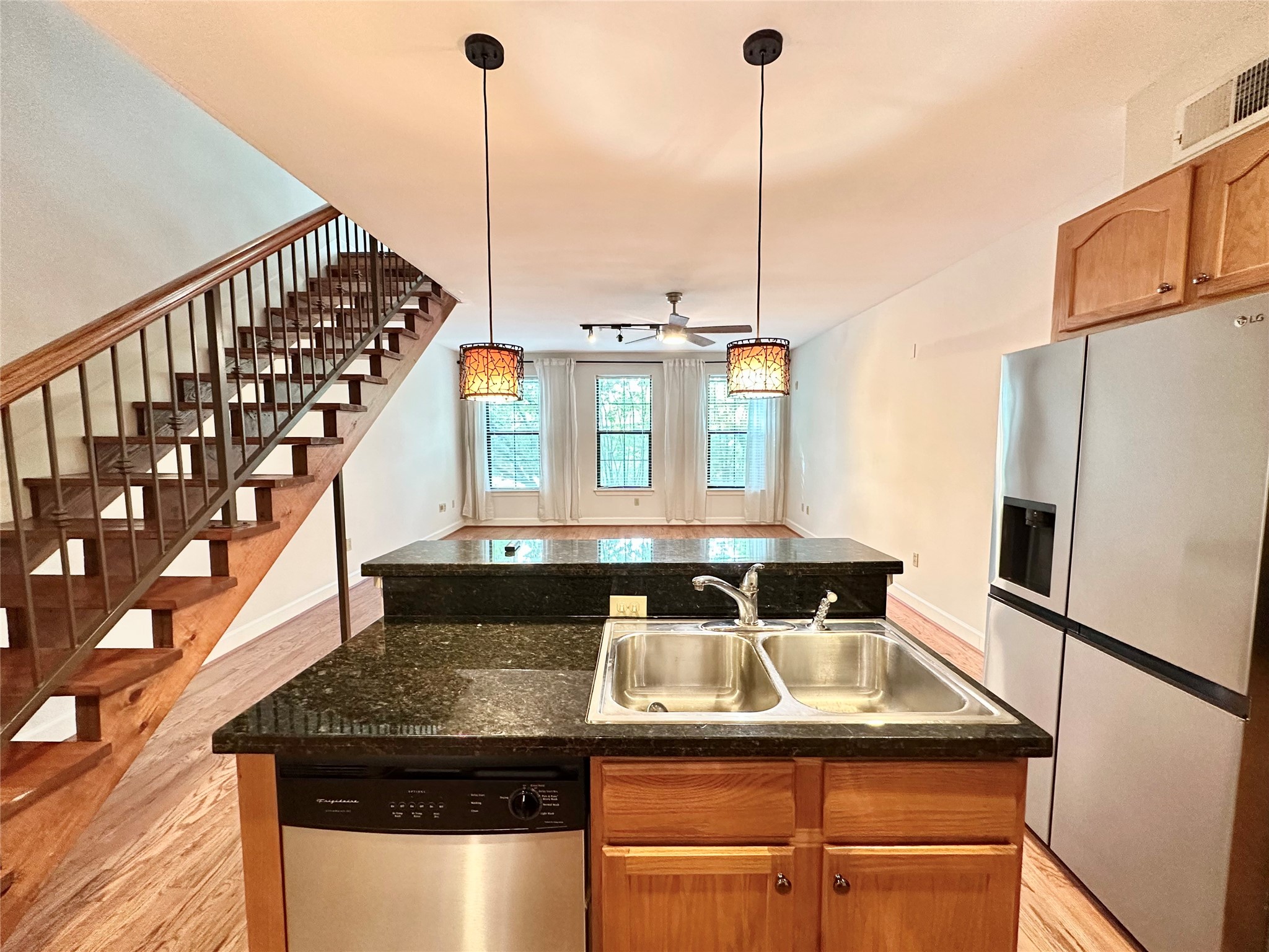 a kitchen view with a sink a refrigerator and wooden floor