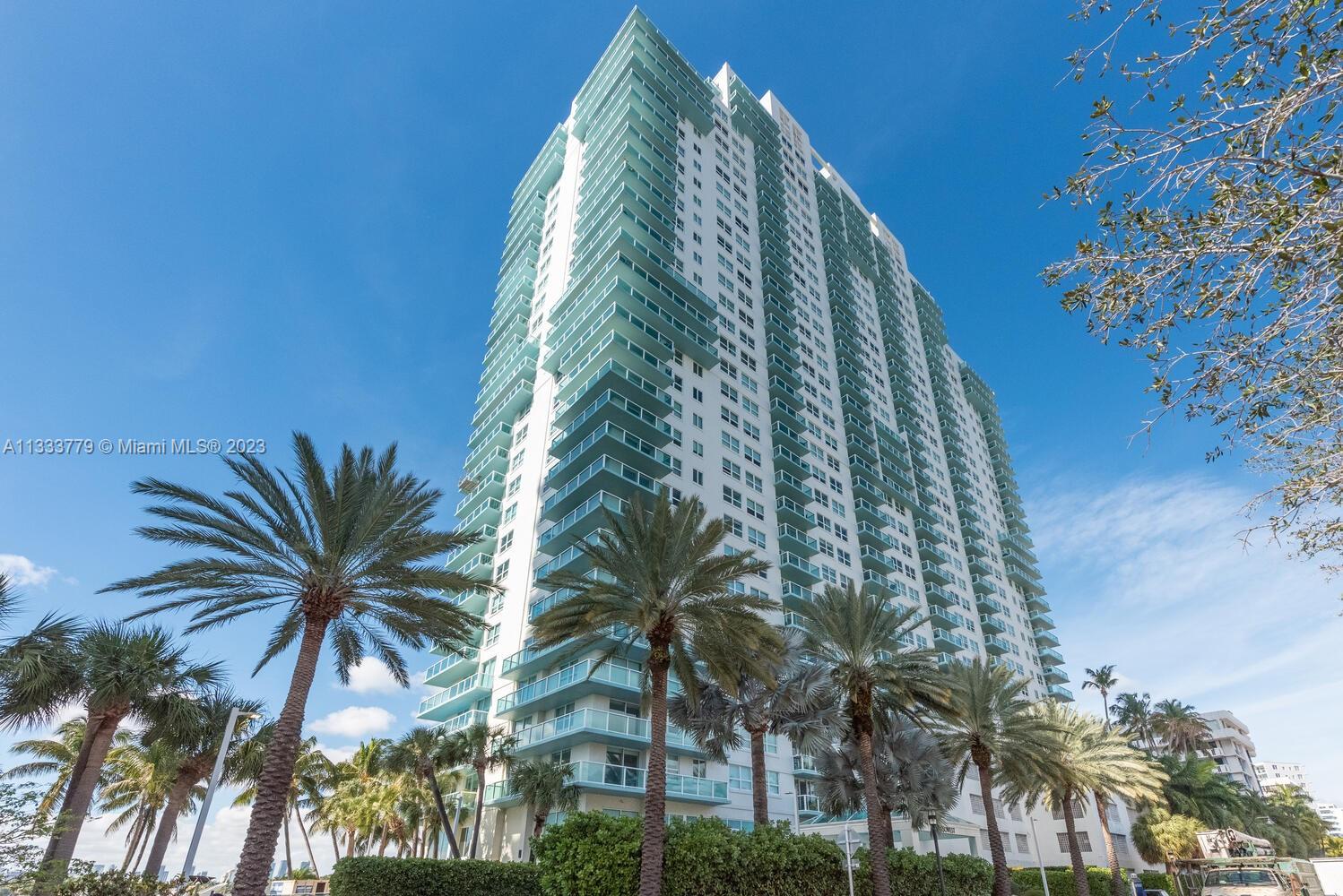 650 West Avenue, Unit 406 Miami Beach, FL 33139 - Photo 1 of 20 a view of a multi story residential apartment building with a yard and potted plants