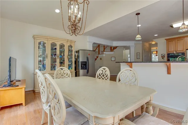 a living room with stainless steel appliances kitchen island granite countertop furniture and a chandelier
