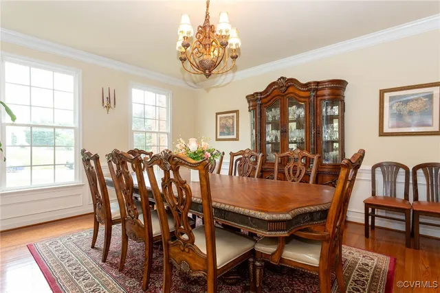 a dining room with furniture a chandelier and wooden floor
