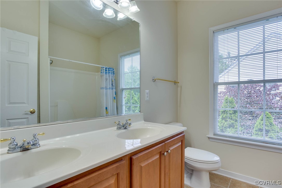 1306 Bach Terrace Midlothian, VA 23114 - Photo 29 of 50 a bathroom with a granite countertop sink toilet a large mirror and a window