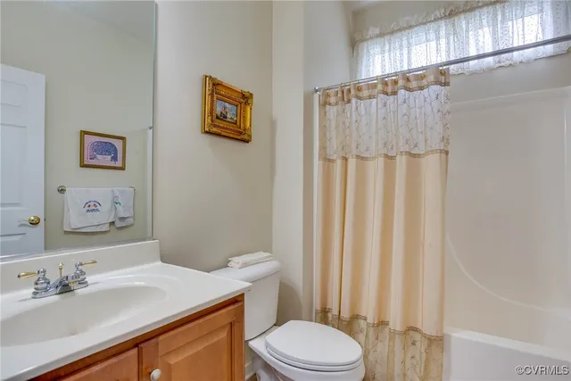 a bathroom with a sink a toilet and shower curtain