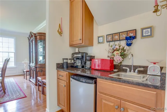a kitchen with stainless steel appliances granite countertop a sink dishwasher and cabinets with wooden floor