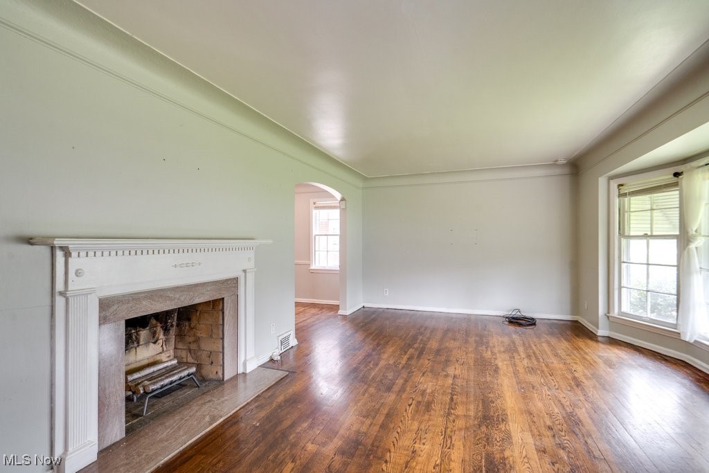 13677 Cedar Road Cleveland, OH 44118 - Photo 9 of 50 Unfurnished living room featuring arched walkways, hardwood / wood-style flooring, and healthy amount of natural light