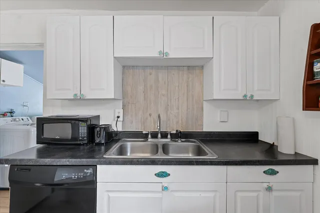 a kitchen with white cabinets and a sink