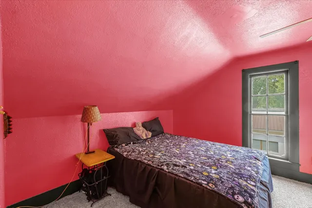 a bedroom with a bed and a window