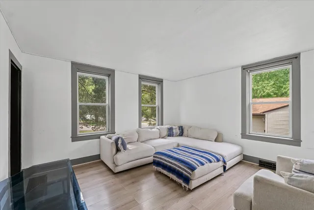 a spacious bedroom with a bed couch and windows