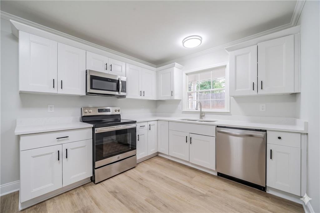 1051 Rowland Road Stone Mountain, GA 30083 - Photo 2 of 25 a kitchen with granite countertop white cabinets and appliances