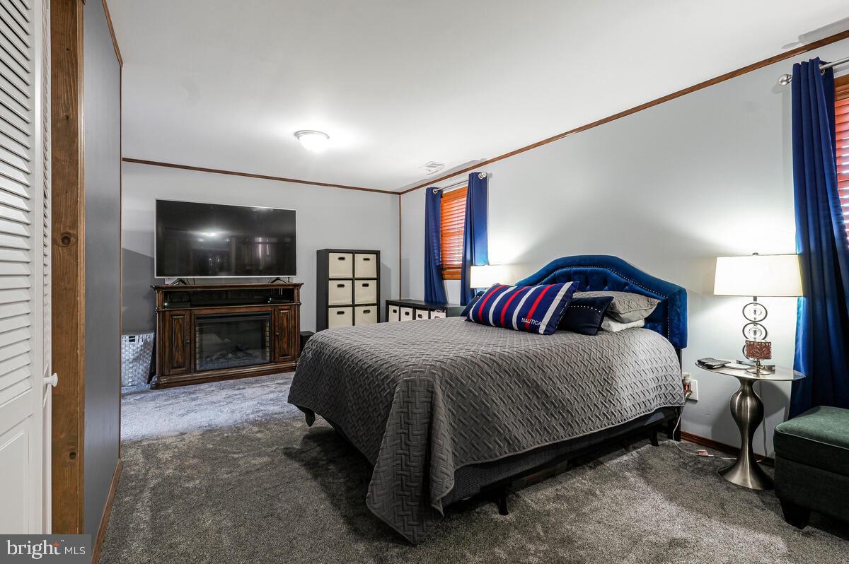 15937 Livingston Road Accokeek, MD 20607 - Photo 25 of 35 a bedroom with a bed and a flat screen tv