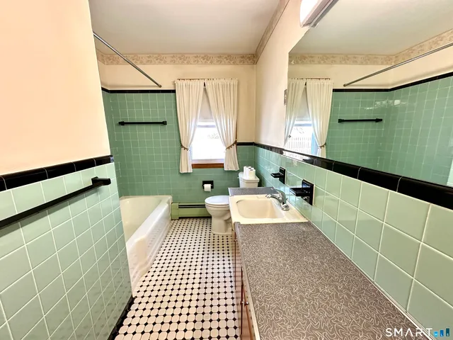 a bathroom with a sink a toilet and mirror