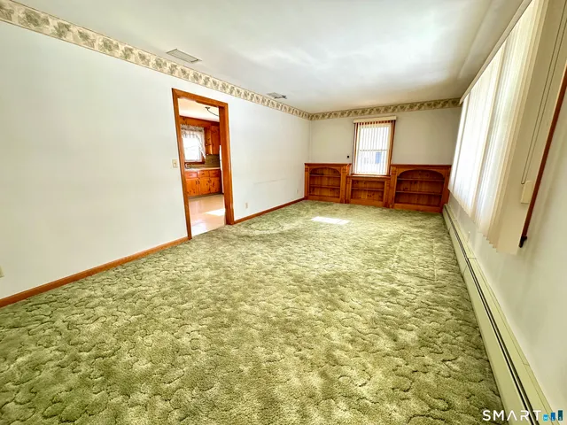 a view of an empty room and dining room