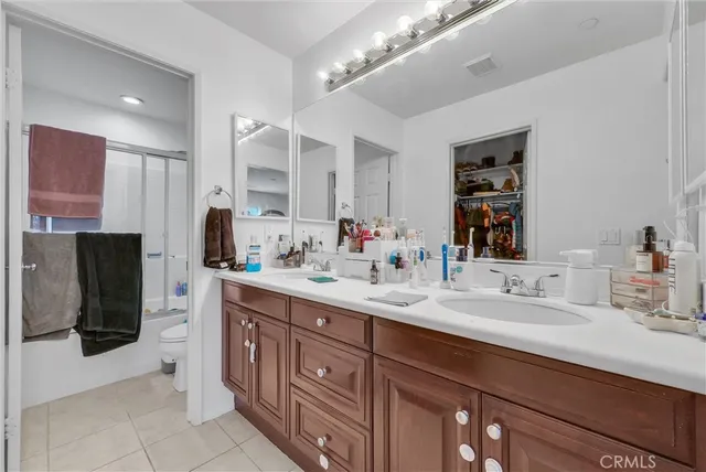a spacious bathroom with a double vanity sink and mirror