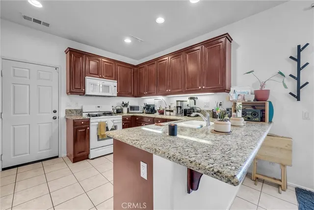 a kitchen with stainless steel appliances granite countertop a stove sink and cabinets