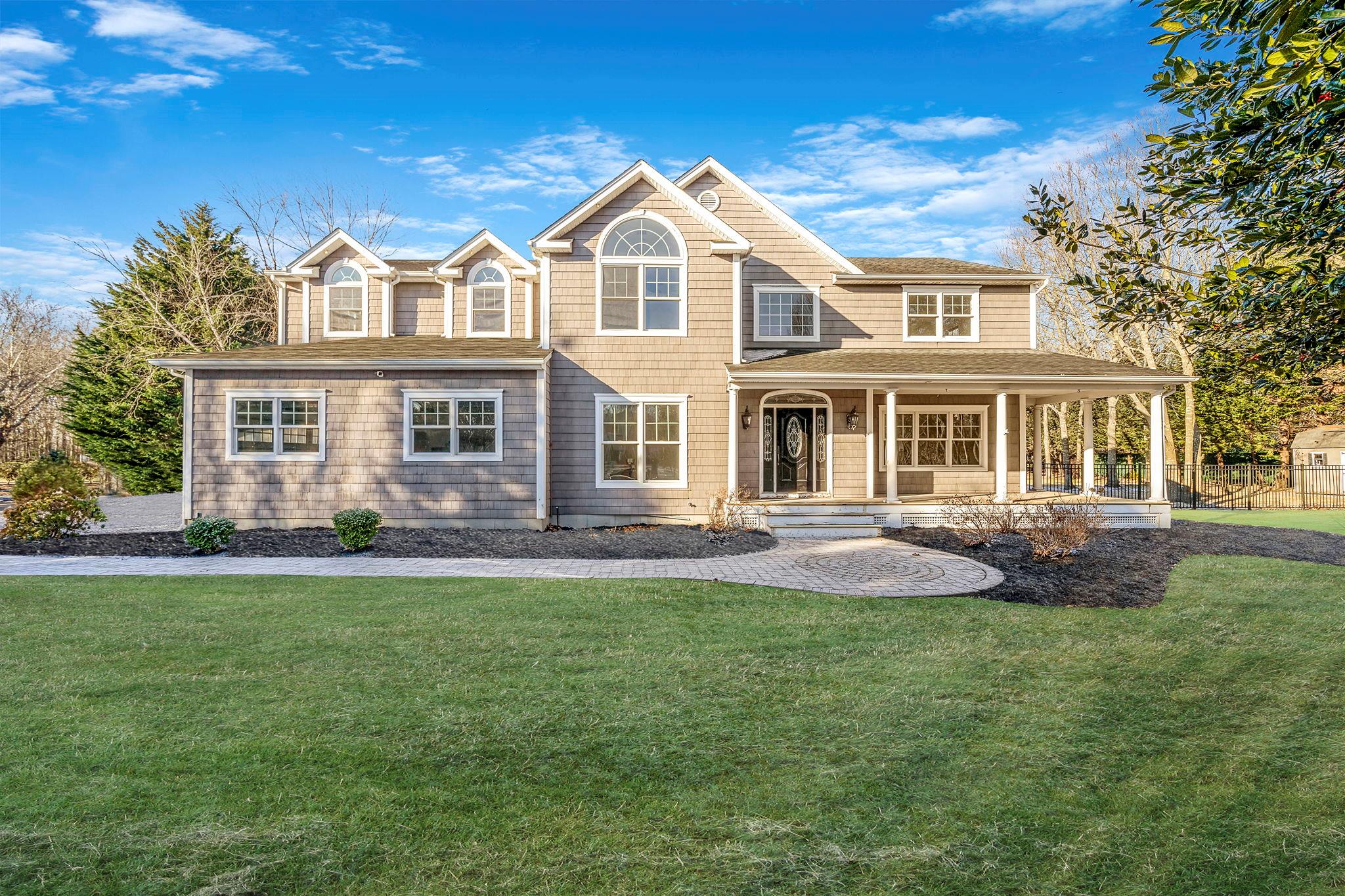 View of front of home featuring covered porch and a front lawn