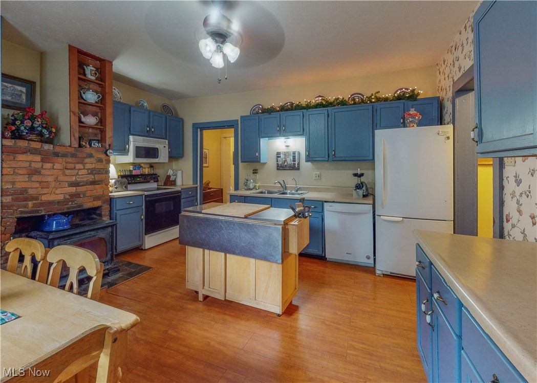 5696 Steubenville Road Southeast Amsterdam, OH 43903 - Photo 8 of 50 Kitchen with white appliances, ceiling fan, sink, and blue cabinetry