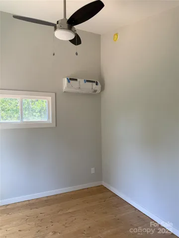an empty room with a window and ceiling fan