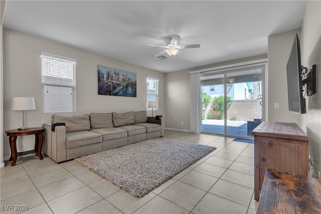 9950 Coyote Echo Court Las Vegas, NV 89166 - Photo 12 of 71 Living area featuring light tile patterned flooring, healthy amount of natural light, and a ceiling fan