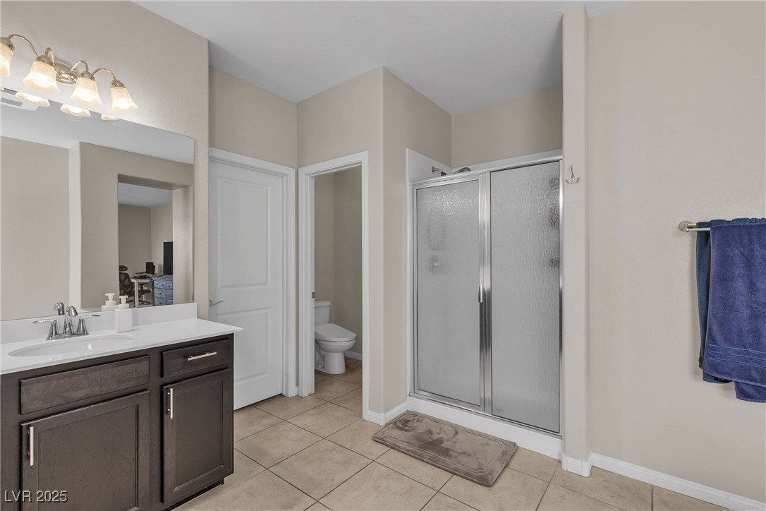 9950 Coyote Echo Court Las Vegas, NV 89166 - Photo 21 of 71 Bathroom with light tile patterned floors, vanity, and a shower stall