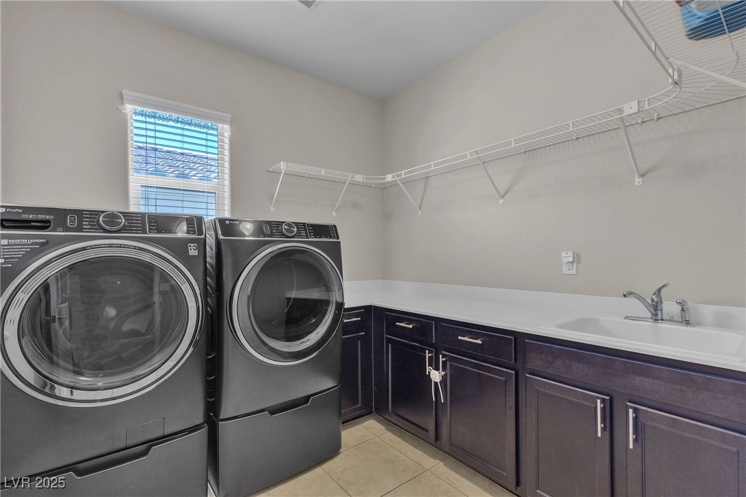 9950 Coyote Echo Court Las Vegas, NV 89166 - Photo 27 of 71 Washroom featuring light tile patterned flooring, washer and dryer, and cabinet space