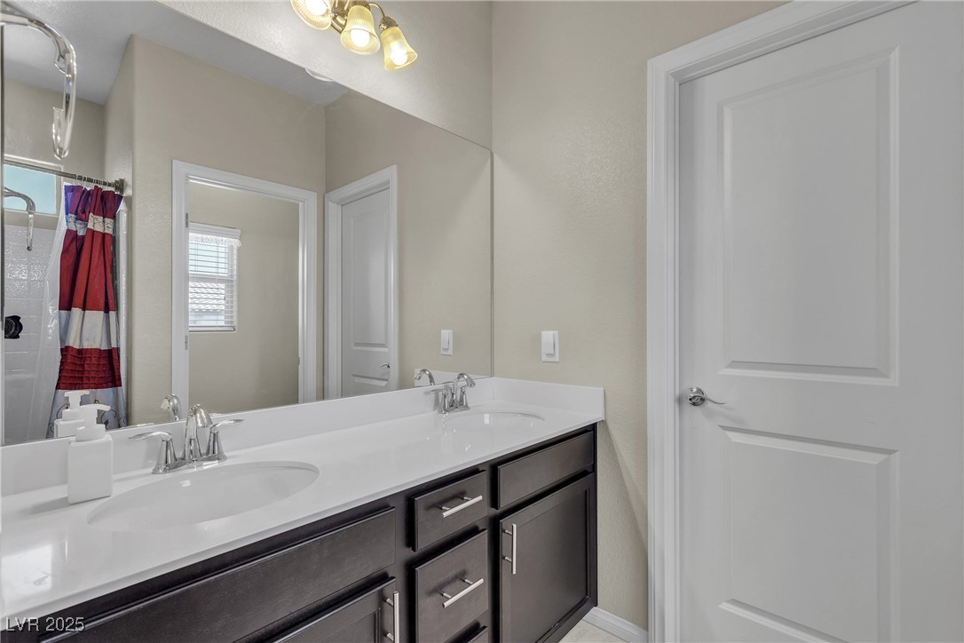 9950 Coyote Echo Court Las Vegas, NV 89166 - Photo 36 of 71 Bathroom featuring a shower with curtain and double vanity