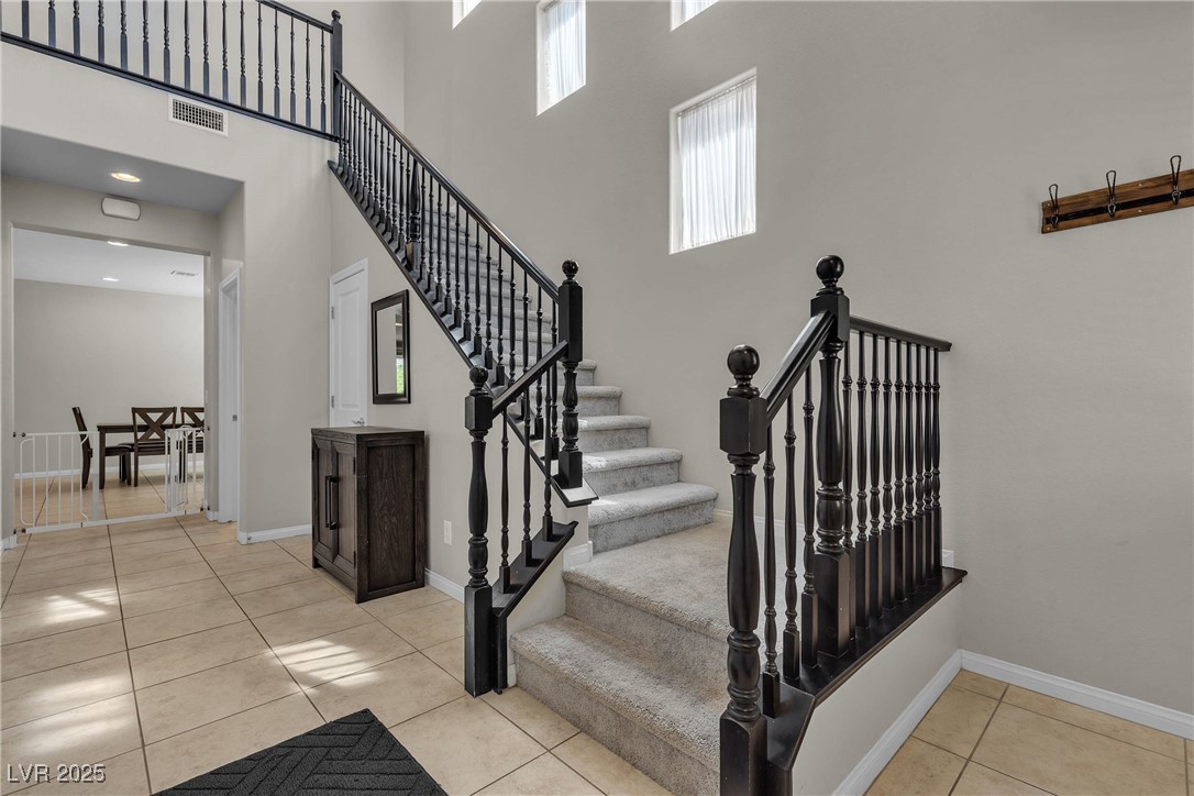 9950 Coyote Echo Court Las Vegas, NV 89166 - Photo 4 of 71 Stairway with a towering ceiling and tile patterned flooring