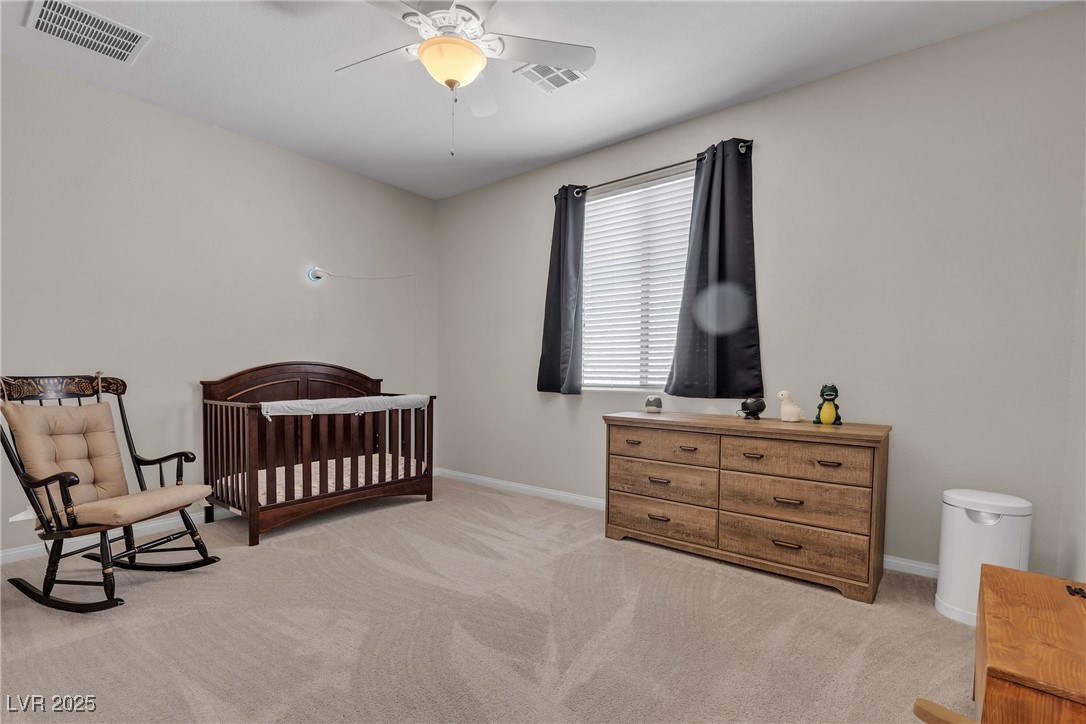 9950 Coyote Echo Court Las Vegas, NV 89166 - Photo 40 of 71 Bedroom featuring a crib, light carpet, and a ceiling fan