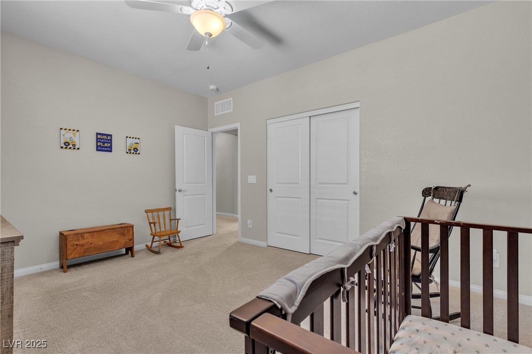 9950 Coyote Echo Court Las Vegas, NV 89166 - Photo 42 of 71 Bedroom featuring light carpet, a ceiling fan, a closet, and a crib