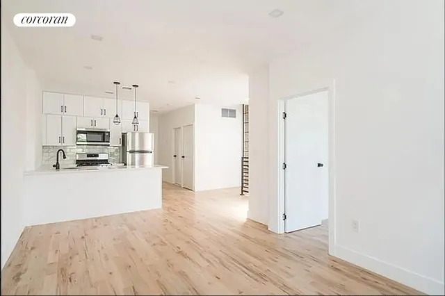 a view of kitchen view refrigerator and wooden floor