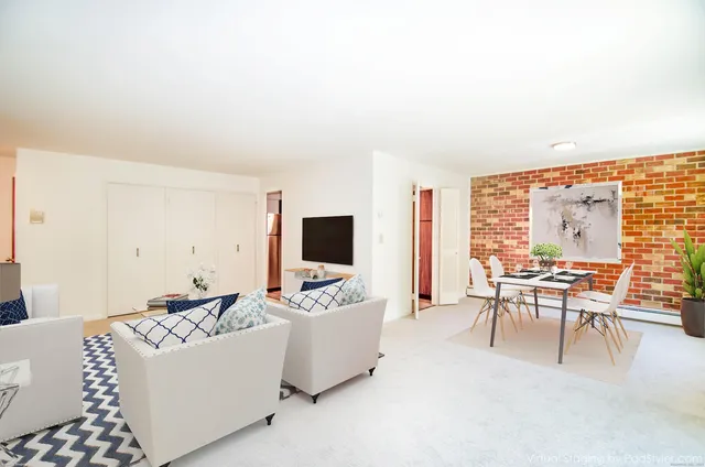 a living room with furniture a flat screen tv and a large window