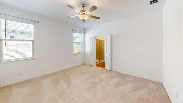 an empty room with a window and a fan