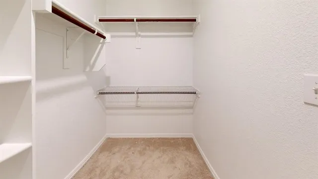 a view of walk in closet with empty racks