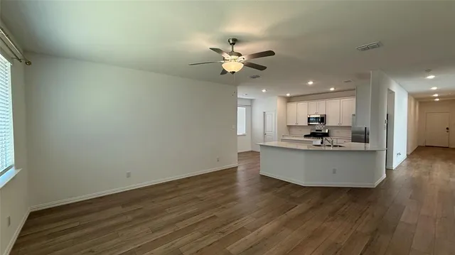 a view of a kitchen with wooden floor and a kitchen space