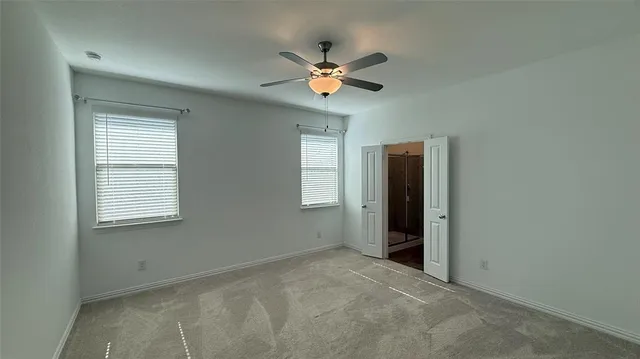 a view of a livingroom with a ceiling fan and window