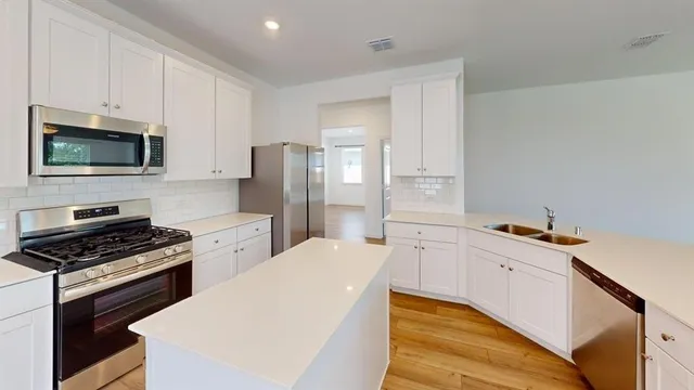 a kitchen with stainless steel appliances a refrigerator stove and microwave