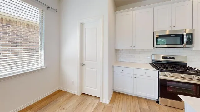 a kitchen with granite countertop wooden cabinets and a stove