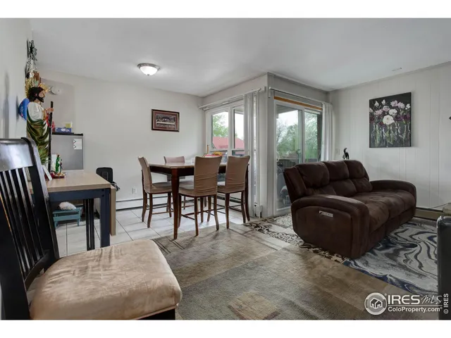 a living room with furniture a dining table and a window