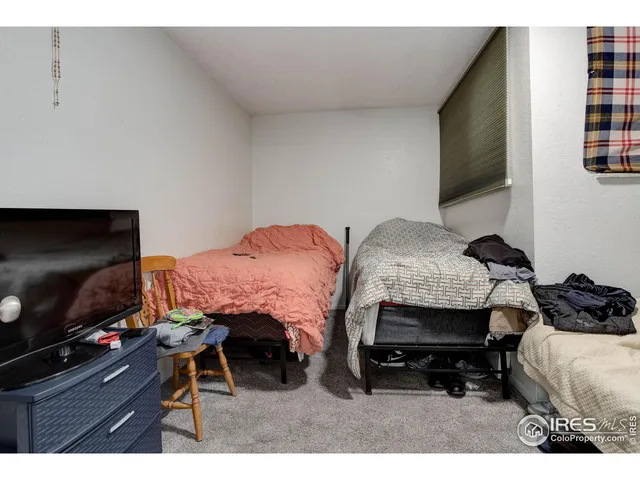 a bedroom with furniture and a flat screen tv