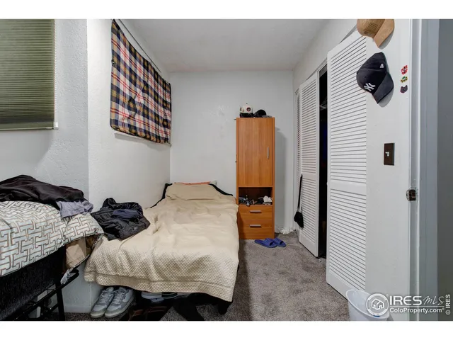 a bedroom with a bed and a flat tv screen on the dresser