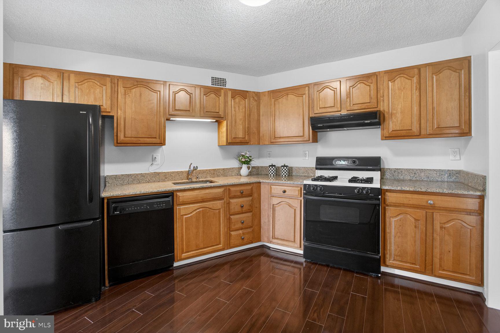 5225 Pooks Hill Road, Unit 1301N Bethesda, MD 20814 - Photo 9 of 26 a kitchen with granite countertop a refrigerator stove top oven and sink