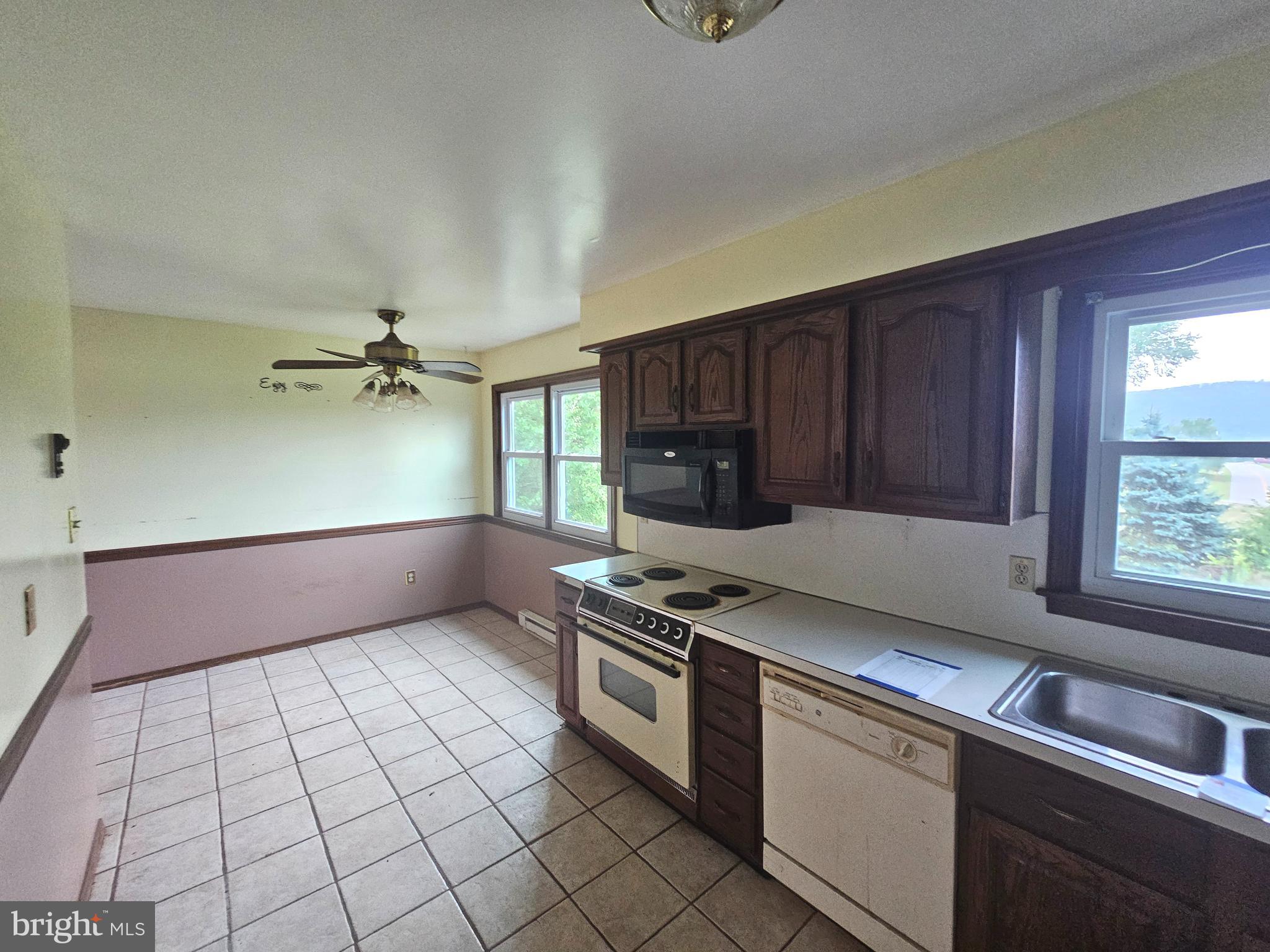 1093 Powells Valley Road Halifax, PA 17032 - Photo 8 of 10 a kitchen with granite countertop a stove a sink and a microwave
