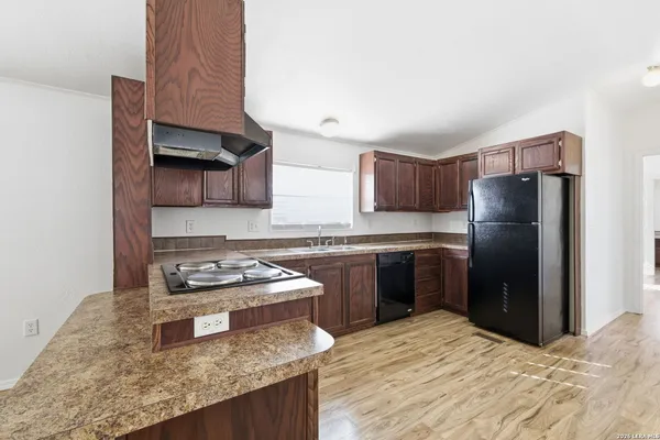 a kitchen with a refrigerator sink and wooden cabinets