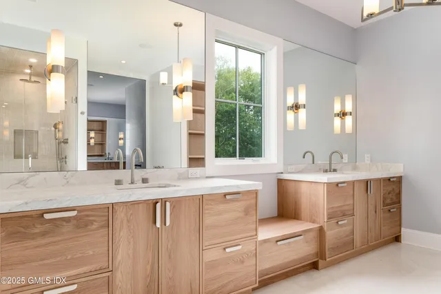 a bathroom with a sink double vanity mirror and a bathtub