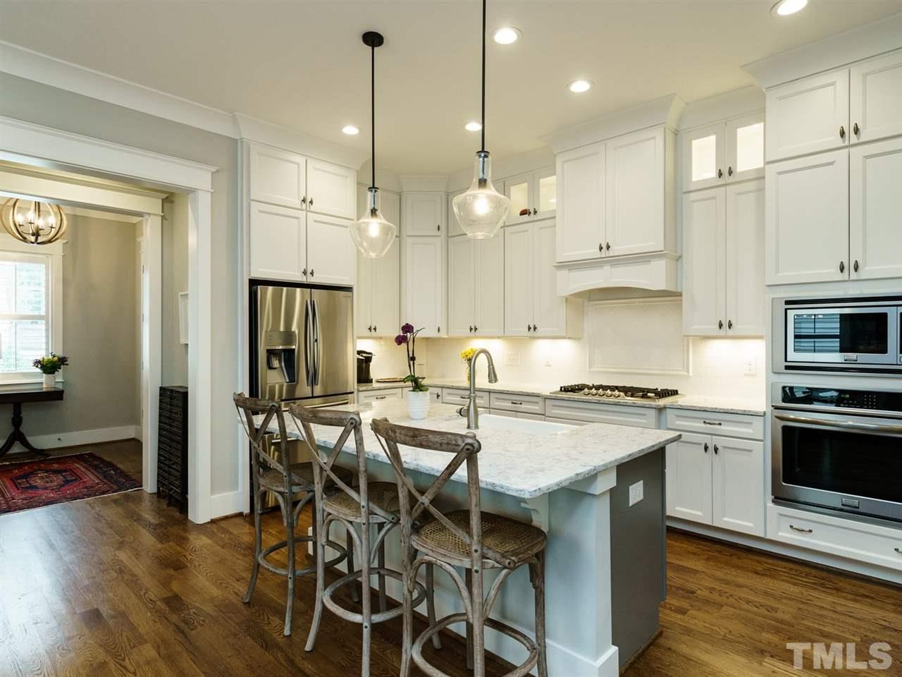 710 Virginia Avenue Raleigh, NC 27604 - Photo 6 of 25 a kitchen with stainless steel appliances a stove a refrigerator a kitchen island a sink cabinets and wooden floor