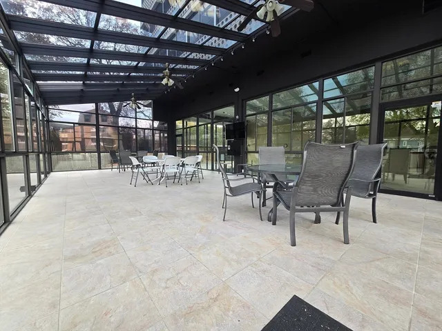 a view of a patio with table and chairs and a barbeque