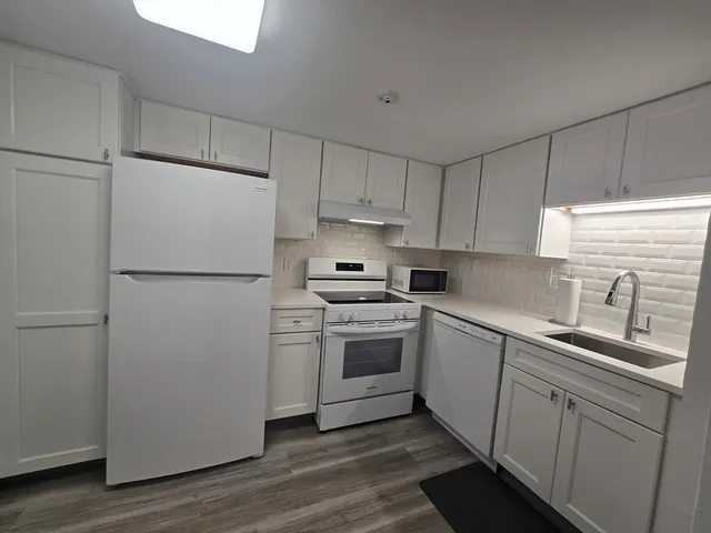 a kitchen with a refrigerator sink and cabinets