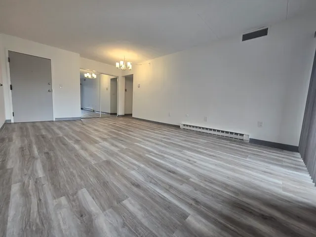 a view of an empty room and wooden floor