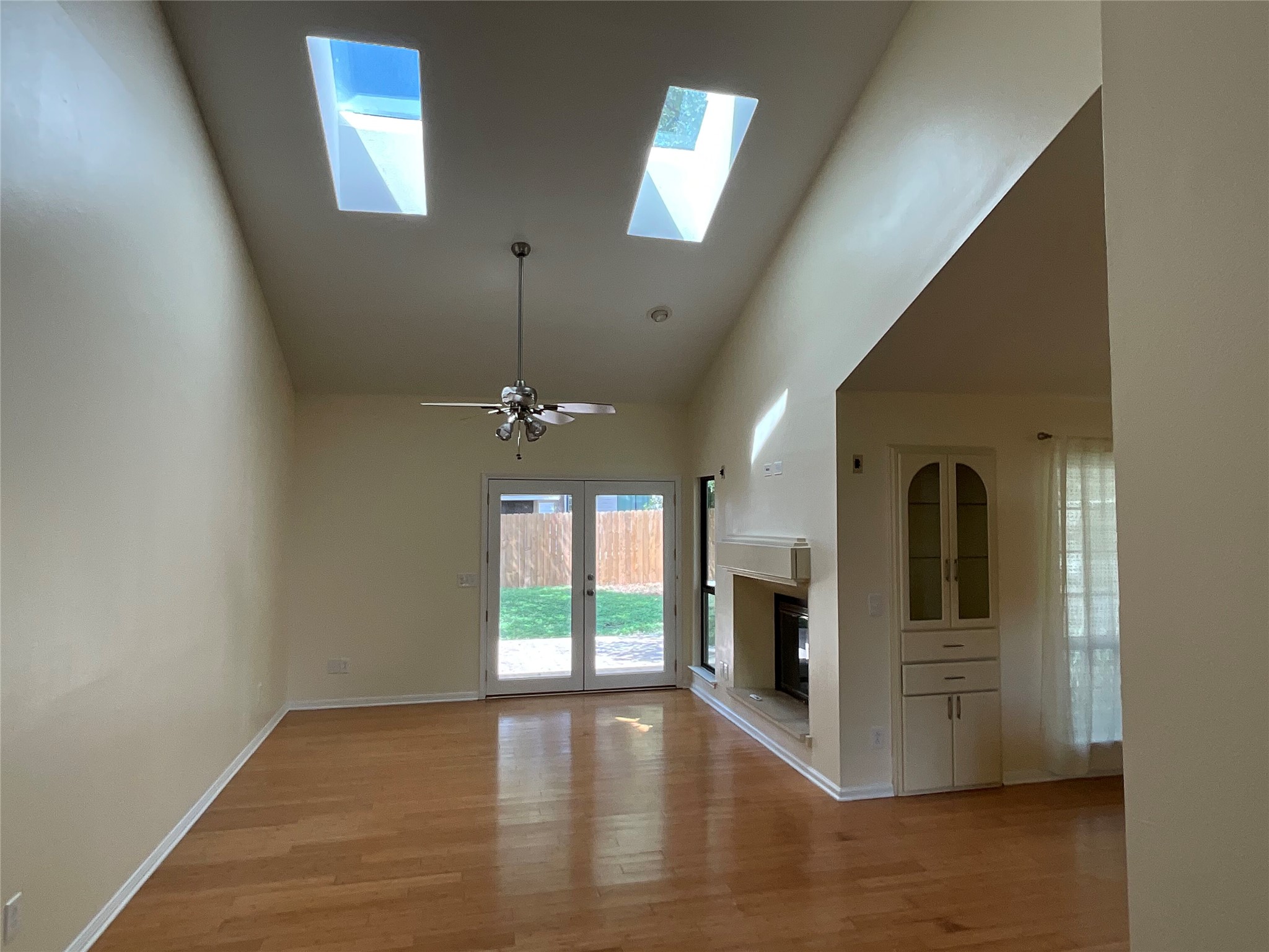 15702 Racine Cove Austin, TX 78717 - Photo 5 of 27 A living space offers a fireplace, built-in storage, and French doors that open to the outdoors.