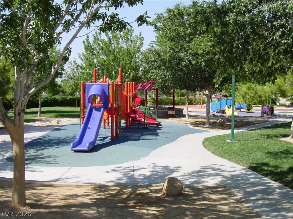 1140 Julie Road Henderson, NV 89002 - Photo 29 of 38 A vibrant community playground features engaging structures set against a backdrop of mature trees and verdant lawns.