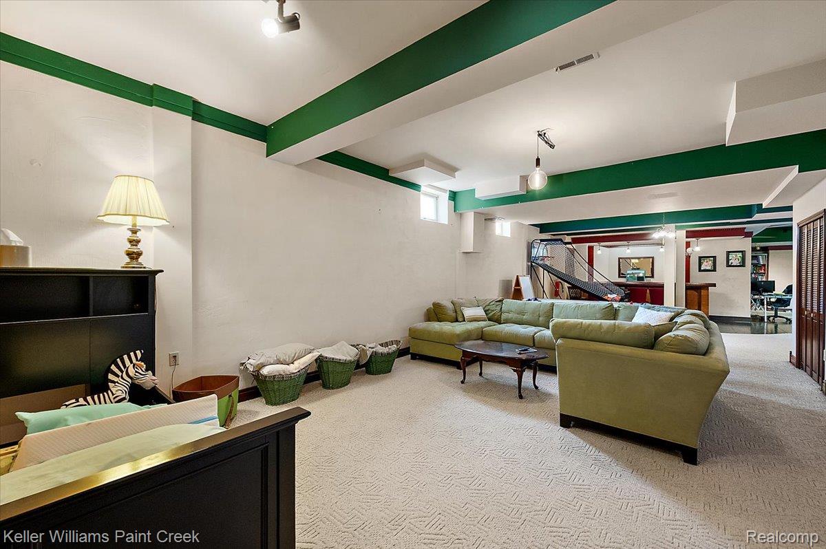 69069 Campground Road Romeo, MI 48065 - Photo 77 of 78 Spacious lower-level room featuring light-toned patterned carpeting and white walls with green ceiling trim